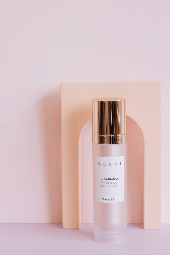 Monat serum vial on minimalist pink background, highlighting luxurious packaging.