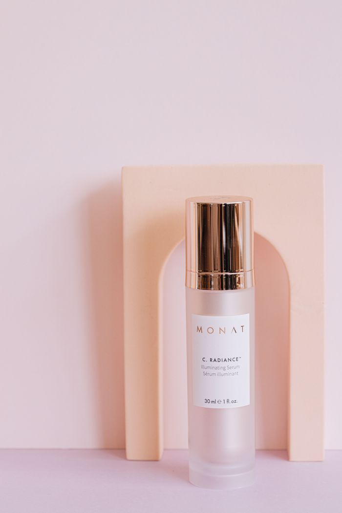 Monat serum vial on minimalist pink background, highlighting luxurious packaging.