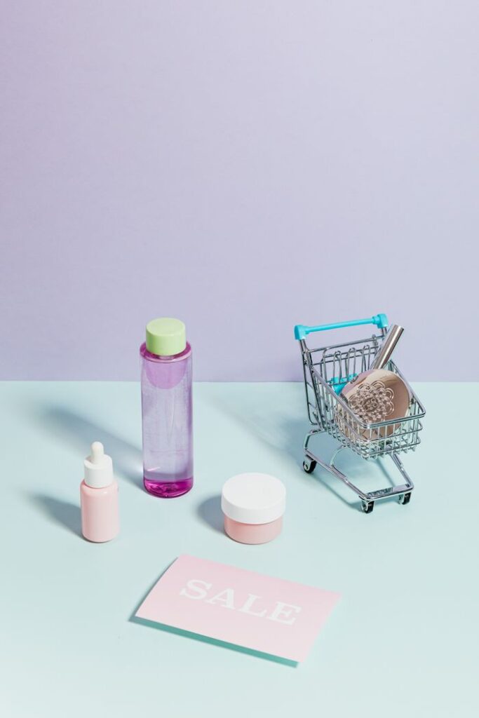 Elegant flatlay of cosmetics and a mini shopping cart, ideal for sales promotions.